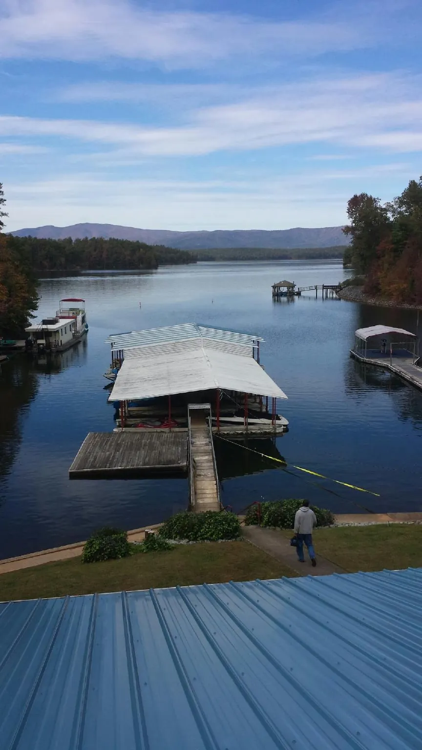 View across a lake from a newly installed blue metal roof in Troutville
