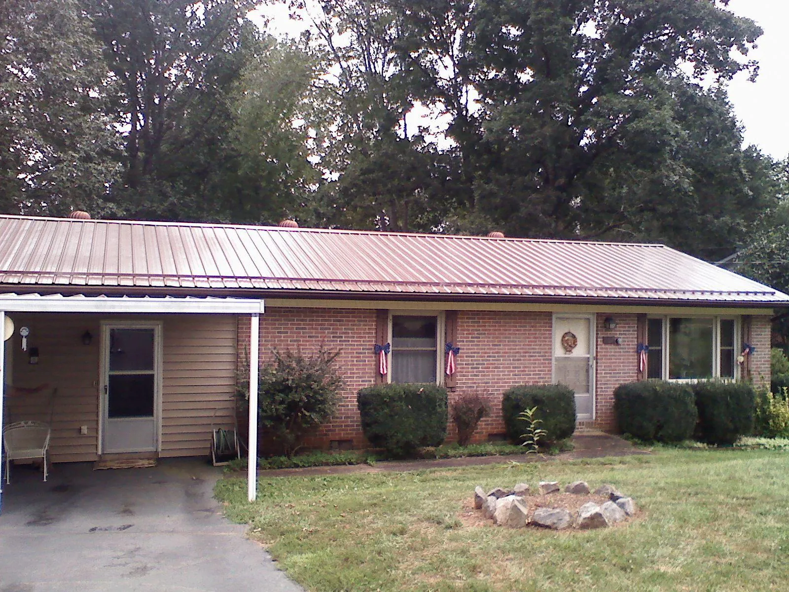 Bronze metal roof and carport on a brick ranch home — Roof Repair work by our crew in Troutville